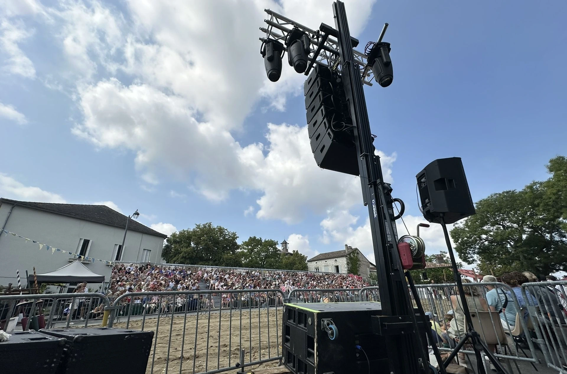 Public dans le gradin avec en premier plan un tour avec un line array