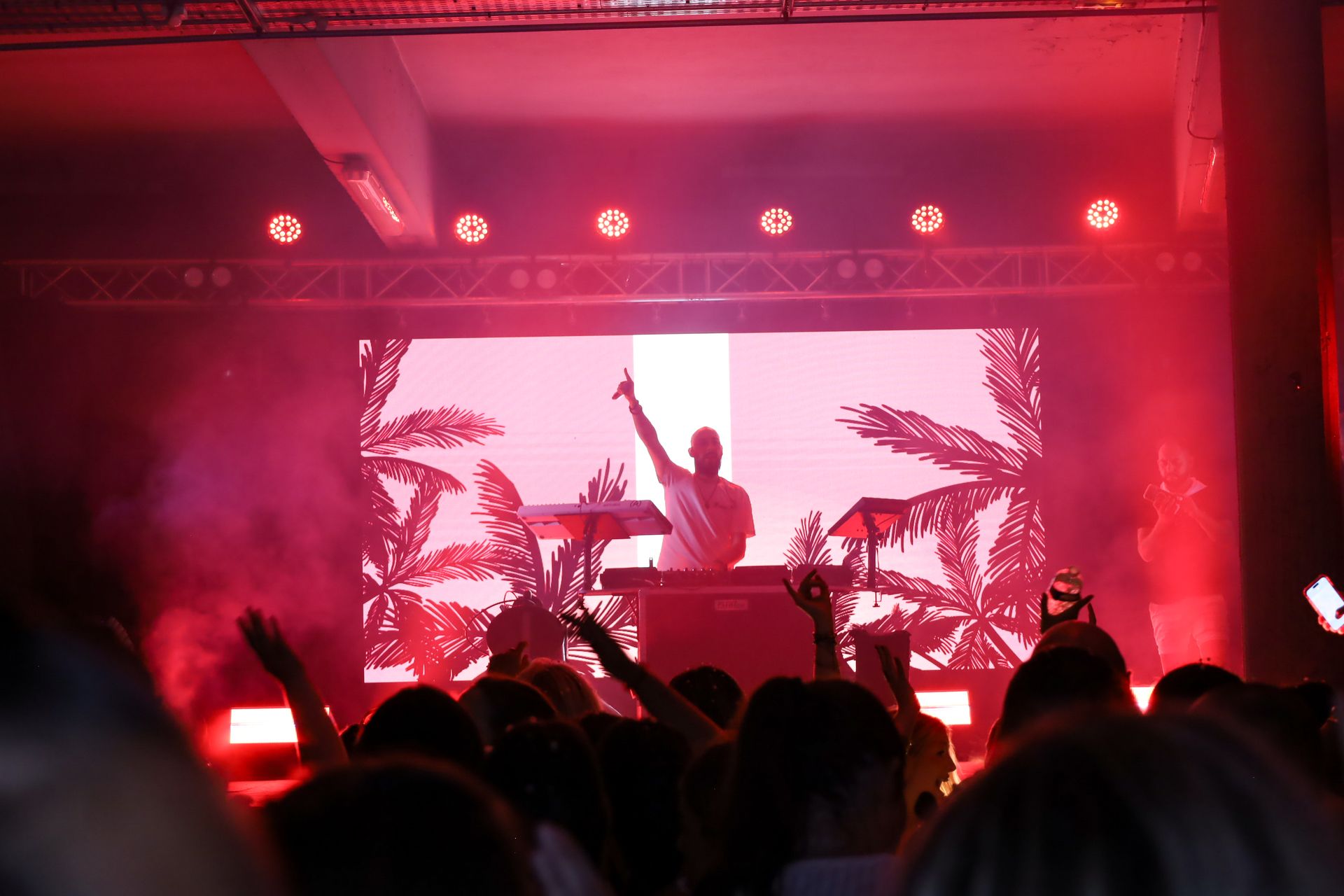 Silouhette du DJ avec écran led en fond et ambiance rouge