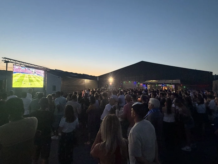 Public avec écran led diffusant un match de football