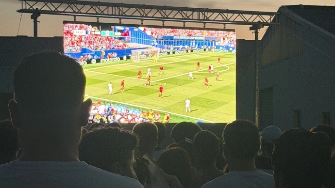 Public avec écran led diffusant un match de football